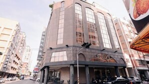 Un edificio de varios pisos con ventanas grandes y una fachada curva.