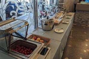 A buffet setup with various food items and serving utensils. - Waughden Business Hotel (Taichung)