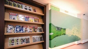Una biblioteca con estanterías de madera llenas de libros y revistas.