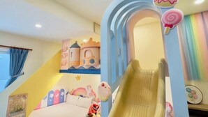 A child's playroom with a slide, castle decorations, and a bed. - Sun Shine Bed and Breakfast (Pingtung)