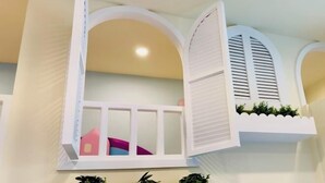 A room with a balcony, a window with shutters, and a small plant on the ledge. - Sun Shine Bed and Breakfast (Pingtung)