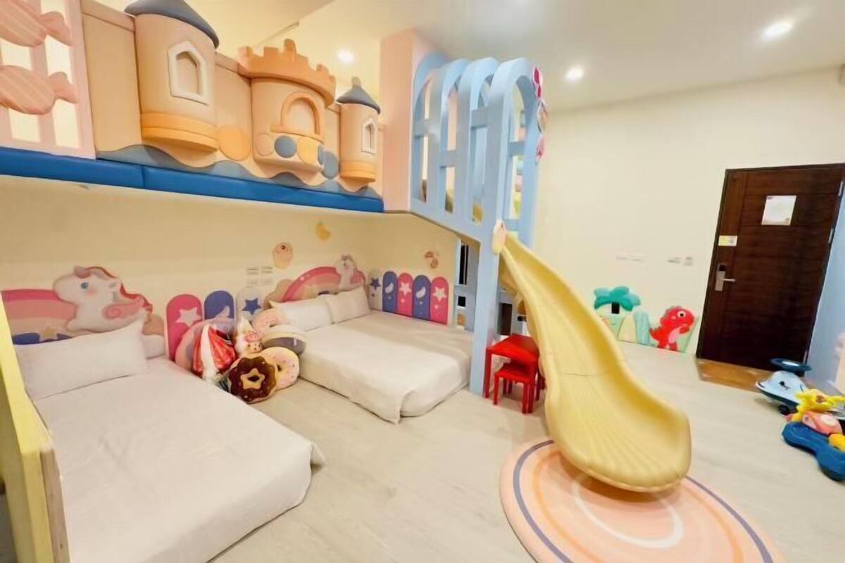 A children's play area with a slide, cushioned seating, and a castle-themed play structure.