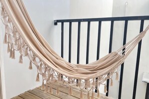 A hammock suspended between a black railing and a white wall. - Sun Shine Bed and Breakfast (Pingtung)