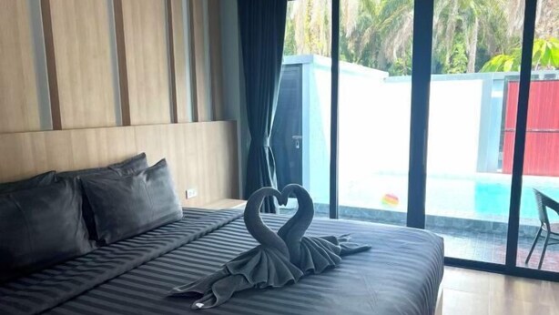 Une chambre d’hôtel avec un grand lit, une vue sur une piscine et une fenêtre avec des rideaux.