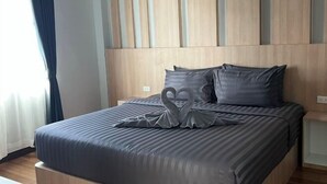 Une chambre d’hôtel avec un lit, une tête de lit et une table de chevet.