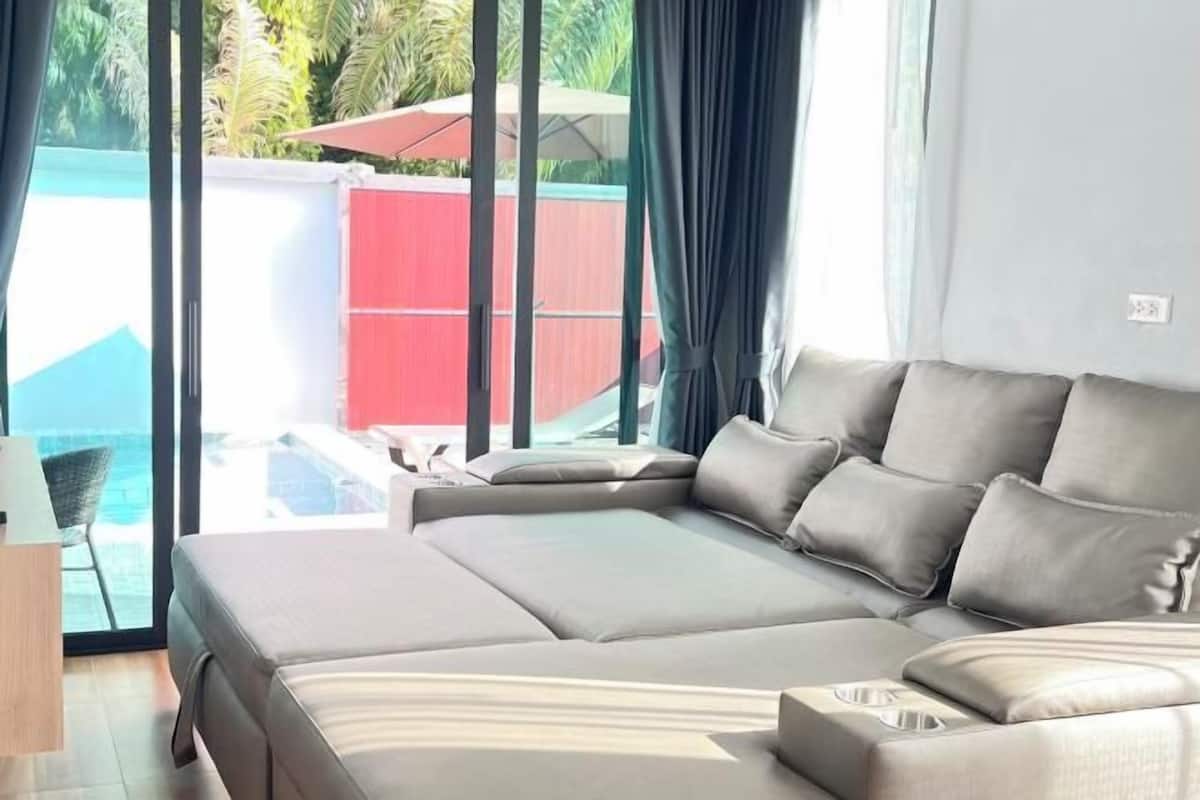 Ein modernes Hotelzimmer mit einem großen Bett, einem kleinen Schreibtisch und Blick auf einen Swimmingpool.