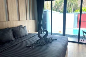 Een hotelkamer met een bed, een groot raam en uitzicht op een zwembad.