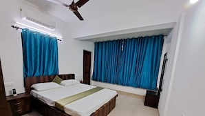 A bedroom with a bed, curtains, a ceiling fan, and a nightstand. - Casa Nadella (Alto de Porvorim)