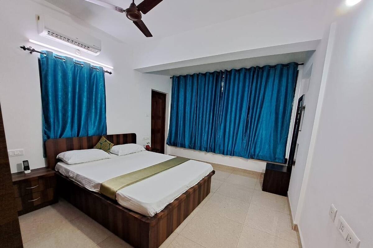 Ein Schlafzimmer mit Bett, Vorhängen, Deckenventilator und Nachttisch.