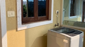 A compact room with a small window and a washing machine. - Casa Nadella (Alto de Porvorim)