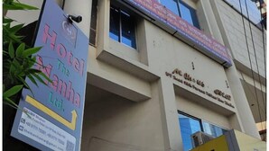 Un edifici de diversos pisos amb diferents senyals, incloent-hi un per a un hotel anomenat "Hotel The Manha" i un altre per "EBL 365".