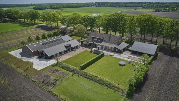 An aerial view of a large estate with multiple buildings, expansive green fields, and a well-maintained lawn. - Group farmhouse with large garden and wideviews (Elsendorp)