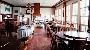 A restaurant with round tables and chairs, large windows, and hanging pendant lights. - Liching Garden Village (Nantou)