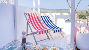 Two striped lounge chairs on a balcony with a clear view of the landscape. - Pinky Promise Villa (Pingtung)
