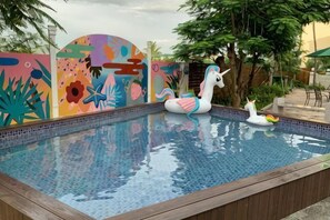 A swimming pool with colorful murals, a unicorn float, and a small inflatable duck. - Pinky Promise Villa (Pingtung)