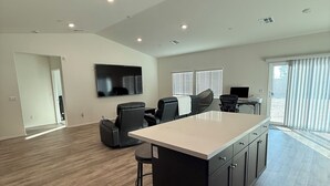 A spacious living area with a large island, a flat-screen TV, and a dining area with chairs. - 5-bedroom House in Marvelous Winchester with AC/Heater (Winchester)