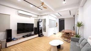 A modern living room with a flat-screen TV, a ceiling fan, a dining table, and a gray sofa. - Sun eden (Nantou)