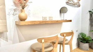 A modern room with a wooden chair and a small table. There is a shelf with a vase and a mirror. - Sun eden (Nantou)
