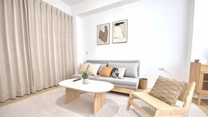 A modern living room with a sofa, a coffee table, a side table, and a chair. - Sun eden (Nantou)