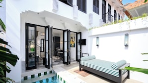 A modern outdoor living area with a pool, a sofa, and a dining area. - Villa Martini Beachside 5  (Canggu)