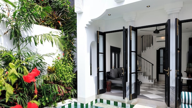 A pool area with a view of a modern interior space, including a staircase and seating area. - Villa Martini Beachside 5  (Canggu)
