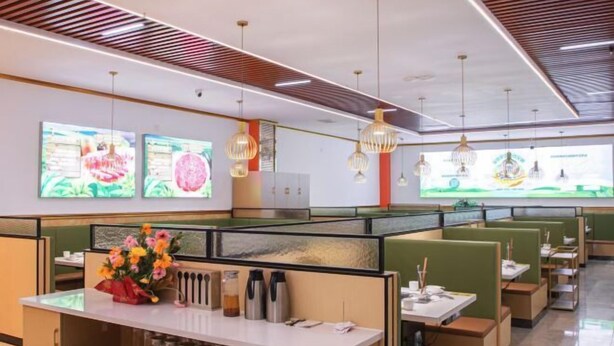 A modern restaurant with booth seating, pendant lighting, and large digital screens on the walls. - Hongshi Road Branch (Junan County)