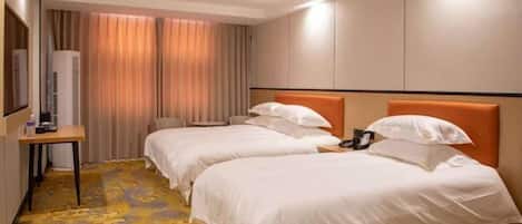 A hotel room with two beds, a desk, and a large window with curtains.