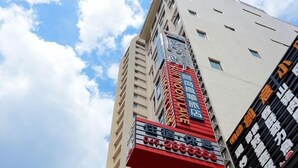 Um edifício alto com vários sinais, incluindo um para um restaurante e outro para um hotel.
