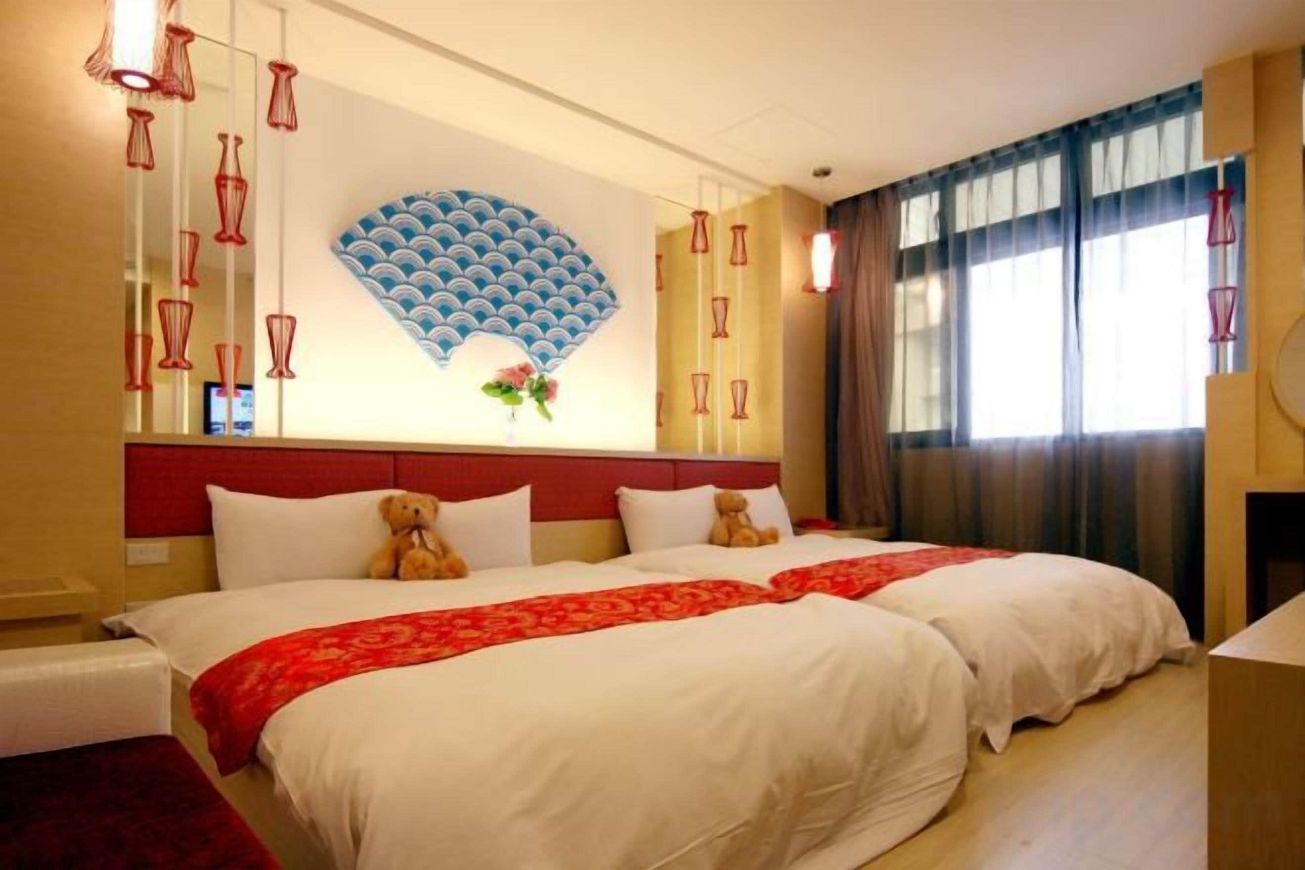 Une chambre d’hôtel avec un grand lit, un mur décoratif et une fenêtre avec des rideaux.