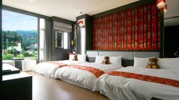 Habitación de hotel con dos camas, un ventanal grande y vistas al exterior.