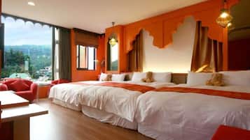 Una habitación de hotel con una cama grande, un escritorio y vistas al exterior.