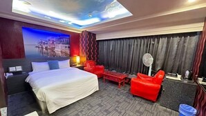 Ein Hotelzimmer mit einem Bett, einem roten Sessel und einem kleinen Tisch.