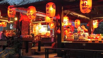 Un restaurante chino tradicional con linternas rojas y techo de paja.