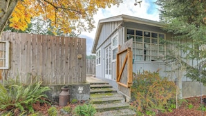 Une maison en bois avec un escalier en pierre menant à une porte.