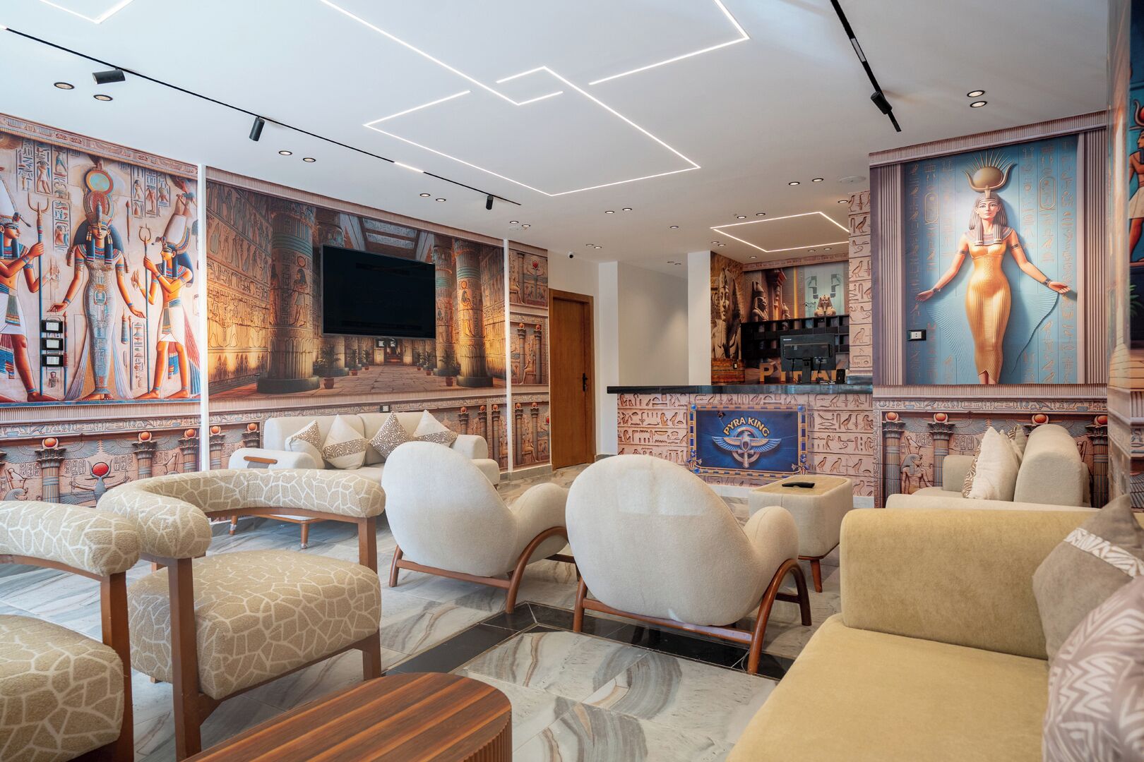 A modern interior with Egyptian-themed murals, comfortable seating, and a bar area.