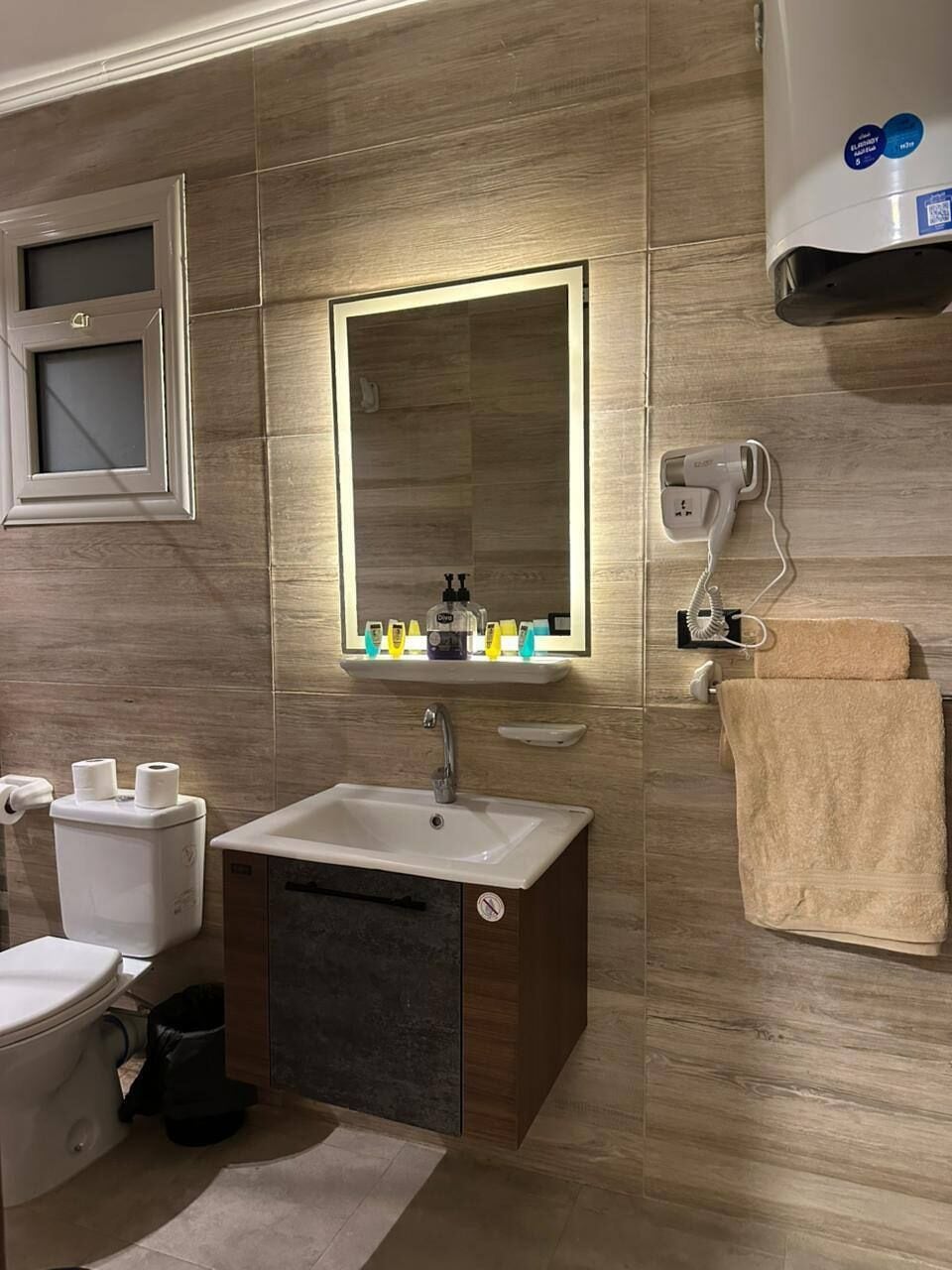 Een moderne badkamer met een wastafel, spiegel en handdoekhouder.