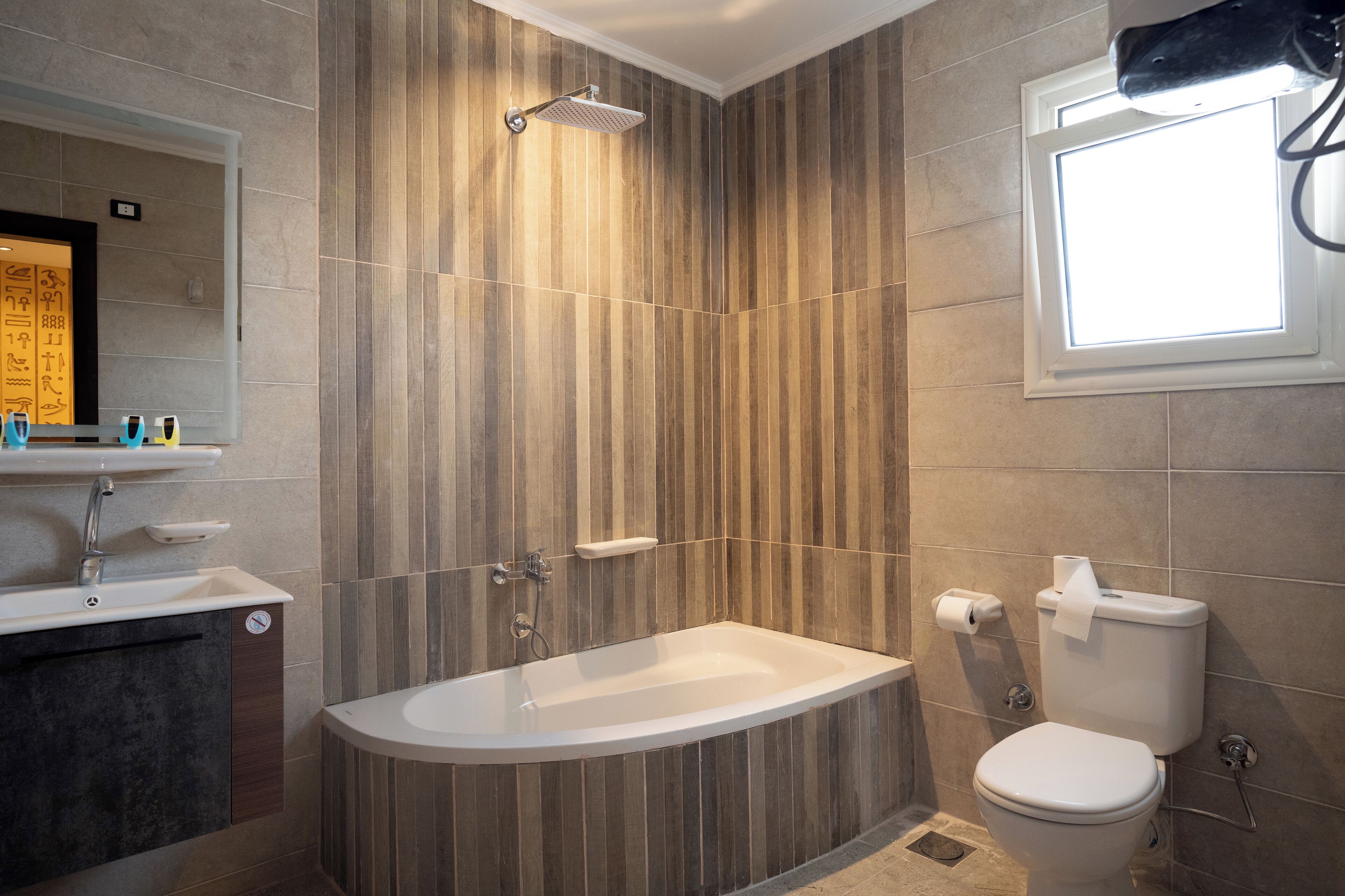 Un baño moderno con una bañera independiente, un inodoro y un lavabo con tocador.