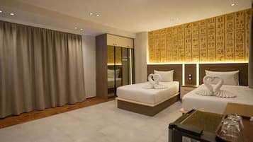 Habitación de hotel con dos camas, un armario y una pared con jeroglíficos.