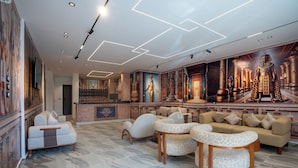 A lobby with a reception desk, seating area, and Egyptian-themed wall art.