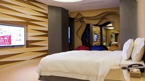 A hotel room with a modern design, featuring a large bed, a television, and a unique ceiling light fixture. - ALL-UR Boutique Motel Hua-Lian Branch (Hualien)