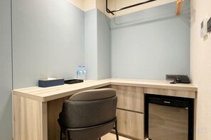 A corner workspace with a desk, chair, and dishwasher. - Fengjia Joie de Inn (Taichung)