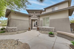 A modern two-story house with a stone facade, a central courtyard, and potted plants. - Mtn-View Patio Oasis! Luxe Family Home in Peoria (Peoria)