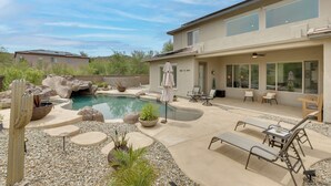Propiedad residencial con piscina, muebles de patio y un cactus.