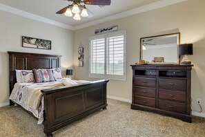 A bedroom with a large bed, a dresser, a mirror, and a ceiling fan. - Mtn-View Patio Oasis! Luxe Family Home in Peoria (Peoria)