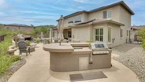 A house with a patio area featuring a built-in grill, outdoor furniture, and a swimming pool. - Mtn-View Patio Oasis! Luxe Family Home in Peoria (Peoria)