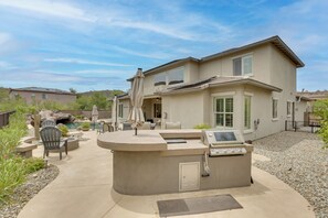 A house with a patio area featuring a built-in grill, outdoor furniture, and a swimming pool. - Mtn-View Patio Oasis! Luxe Family Home in Peoria (Peoria)