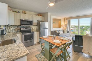 Eine moderne Küche mit Granit Arbeitsplatten, Edelstahlgeräten und einem Essbereich mit Holztisch und Stühlen.