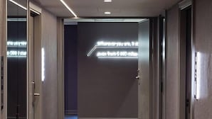 A modern hallway with a dark wall and a neon sign. - Hub Hotel Ximen-Kunming Branch (Taipei)