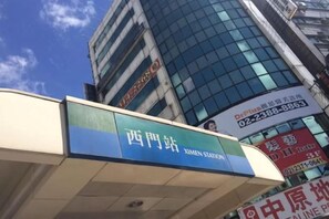 A building with signage for 'XIMEN STATION' and a contact number.