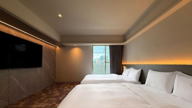 A hotel room with two beds, a flat-screen TV, a large window, and a city view. - Hub Hotel Ximen-Kunming Branch (Taipei)